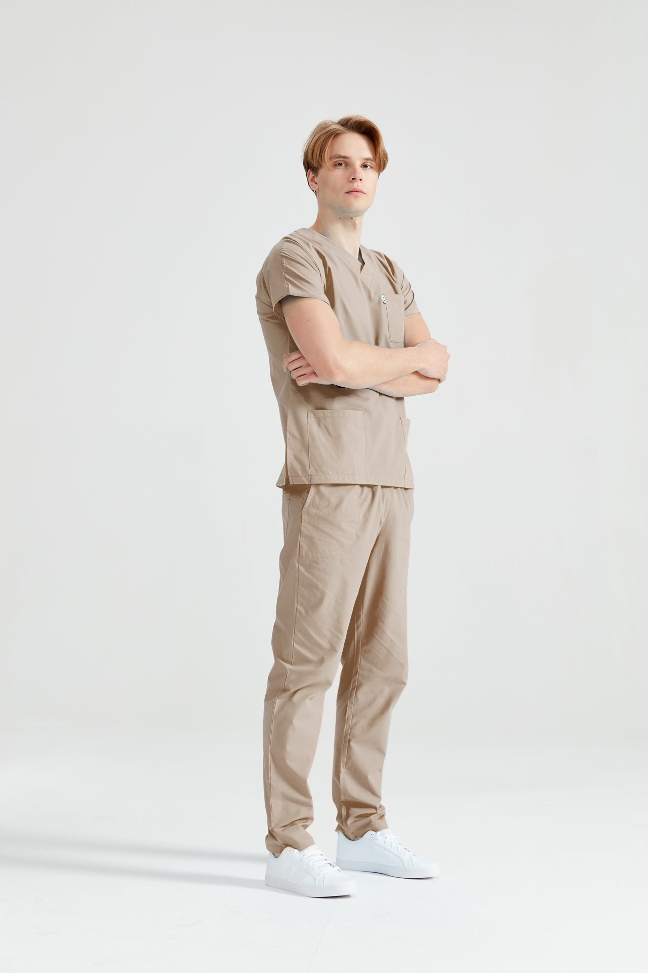 Orvosi asszisztens férfi orvosi öltönyben, elasztán, bézs, profilnézet