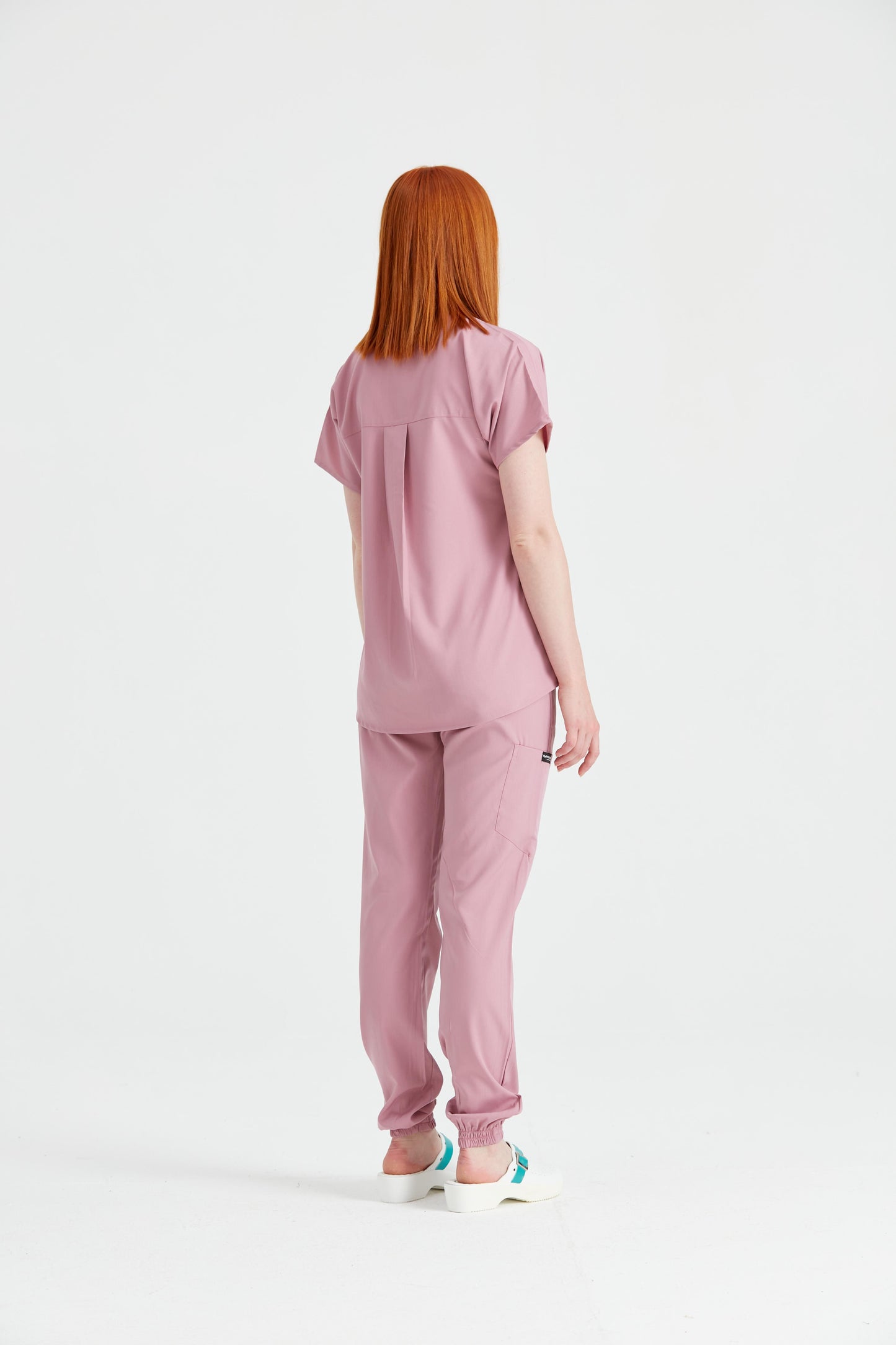 Asistenta imbracata in costum medical activity Roz Pudra, vedere din spate