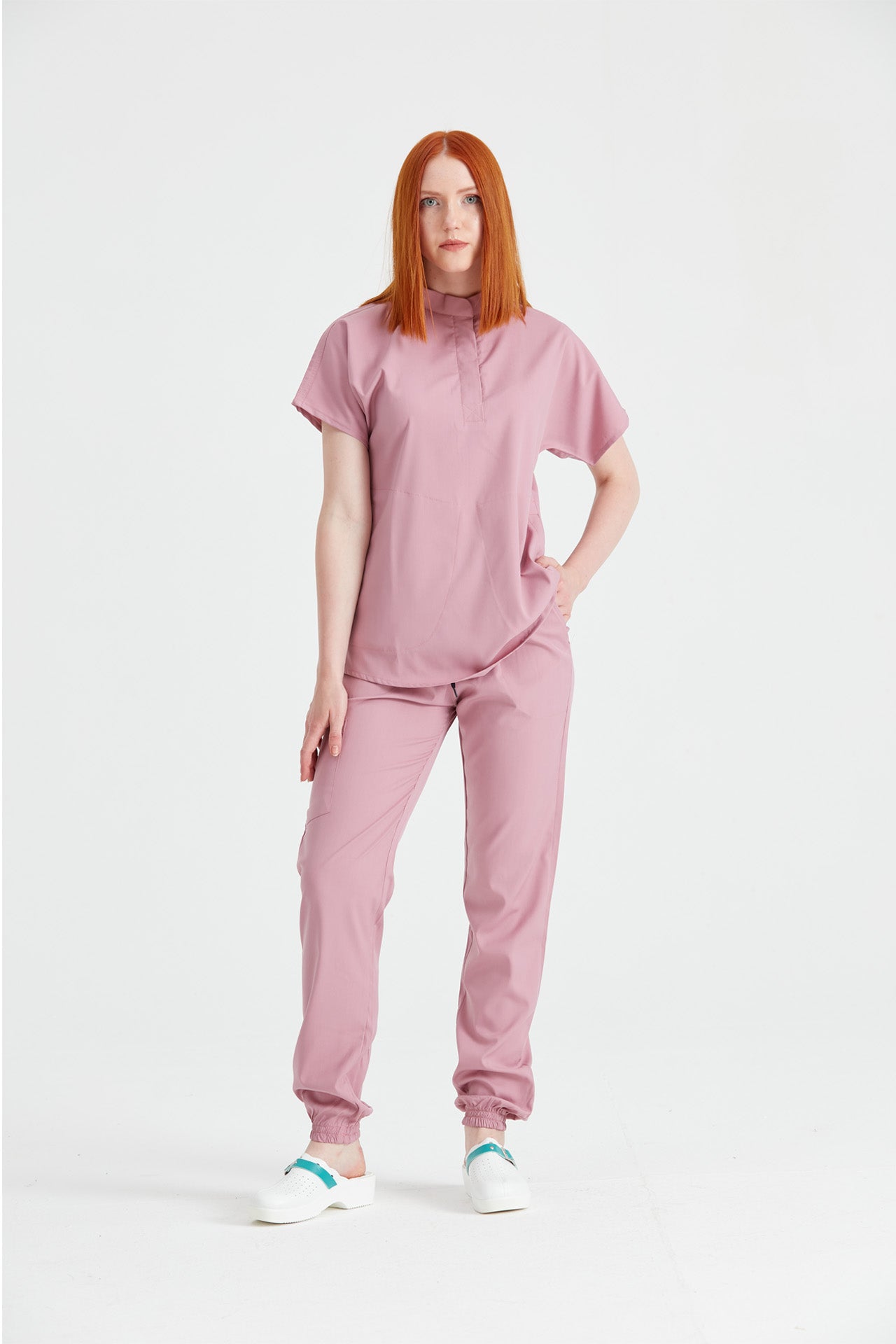 Asistenta imbracata in costum medical activity Roz Pudra, vedere din profil