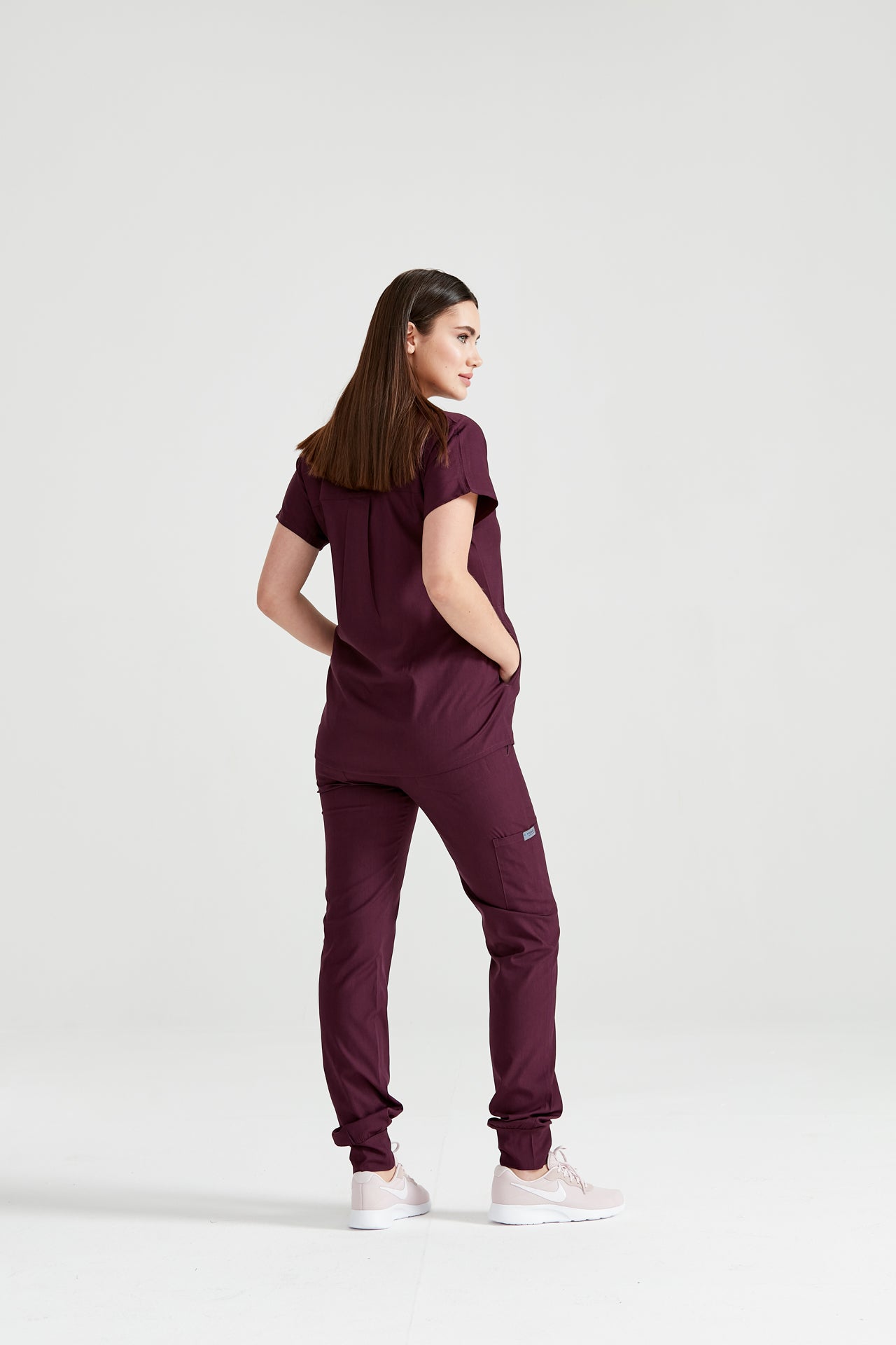 Asistenta medicala imbracata in costum medical grena Sour Cherry, vedere din spate