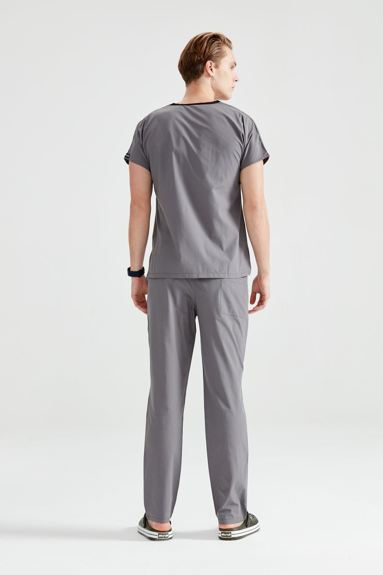 Férfi orvosi öltönybe öltözött orvosi asszisztens, szürke, hátulnézet