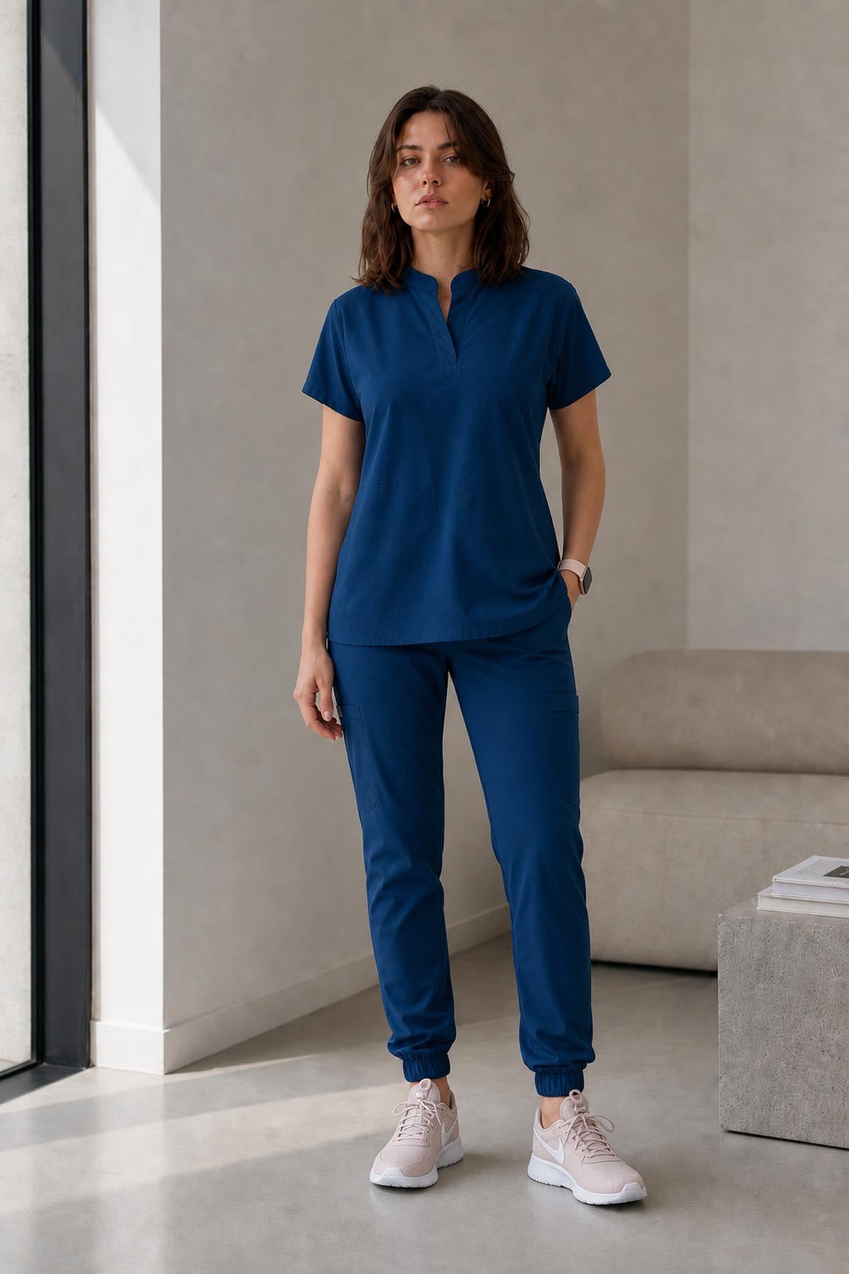 Asistenta medicala purtand bluza uniforma medicala albastru indigo unisex, model Scrub Activity, vedere din fata