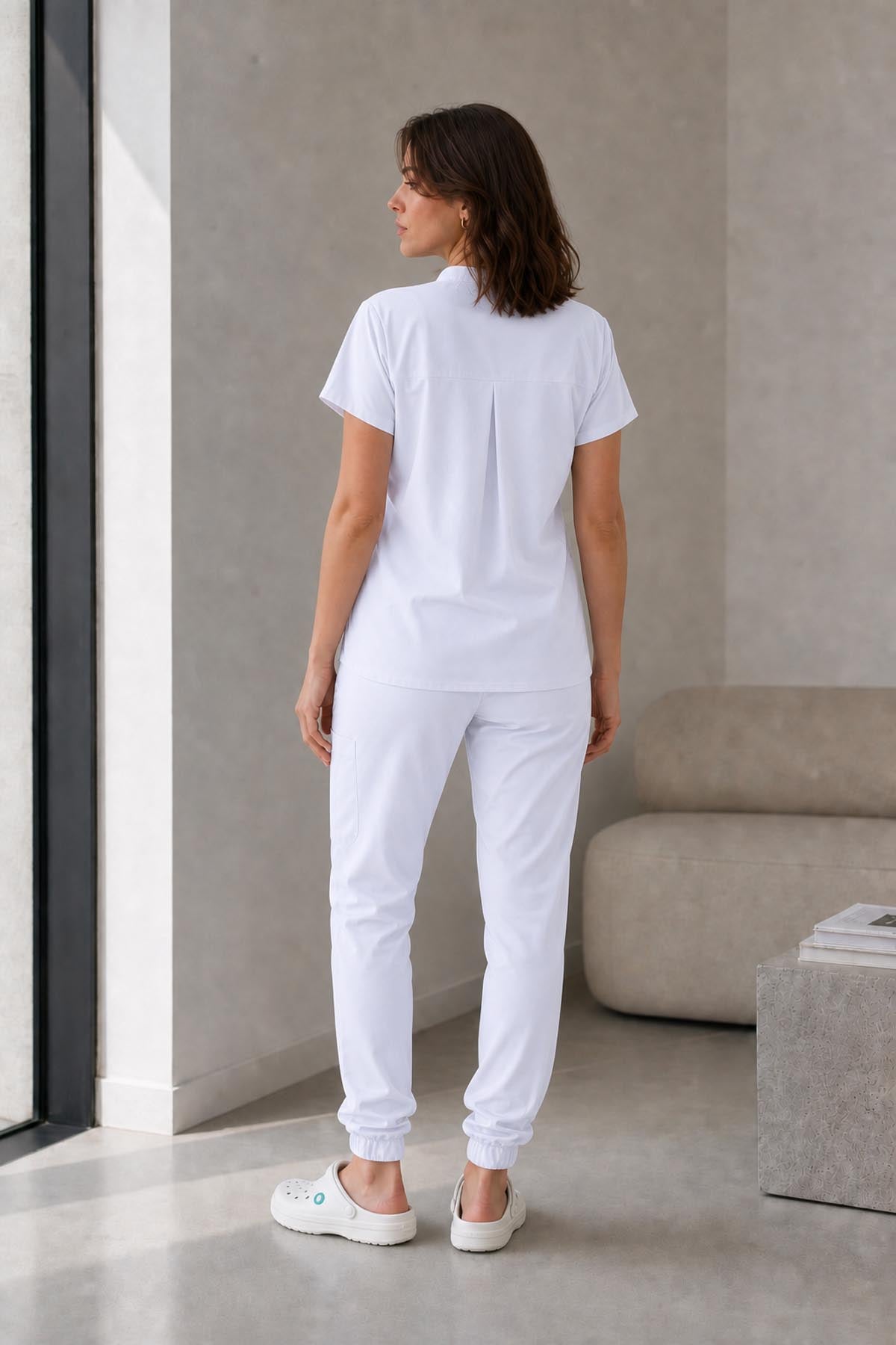 Asistenta medicala purtand bluza uniforma medicala alb unisex, model Scrub Activity, vedere din spate