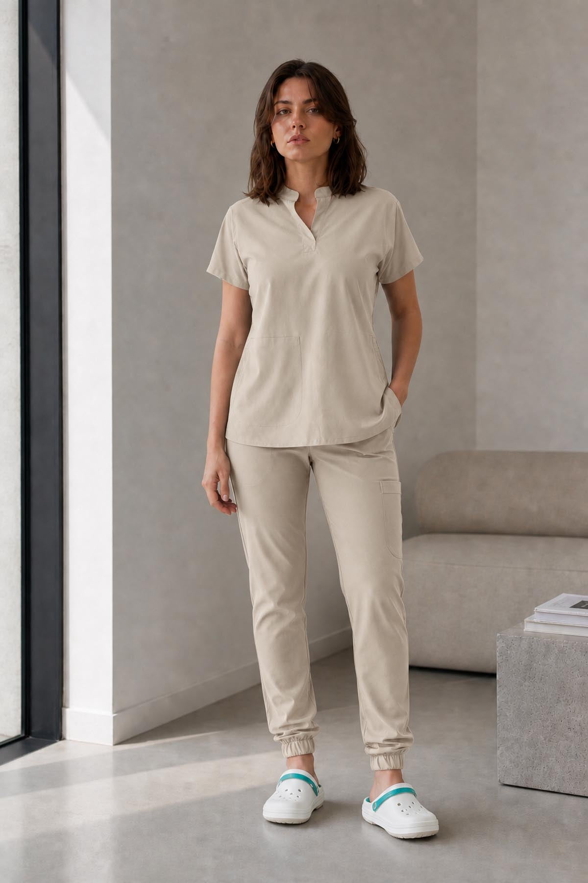 Asistenta medicala purtand bluza uniforma medicala bej unisex, model Scrub Activity, vedere din fata
