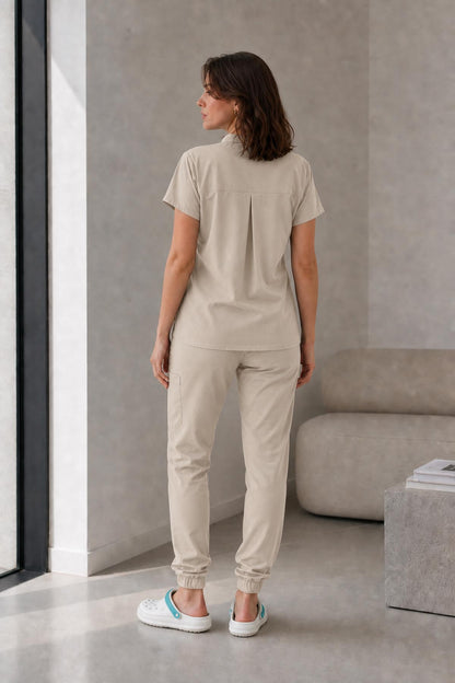 Asistenta medicala purtand bluza uniforma medicala bej unisex, model Scrub Activity, vedere din spate