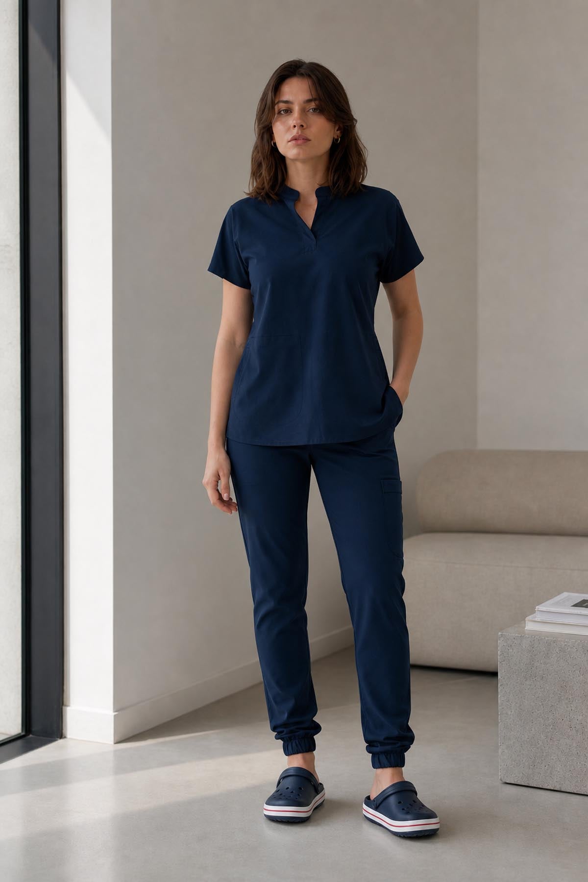 Asistenta medicala purtand bluza uniforma medicala bleumarin unisex, model Scrub Activity, vedere din fata