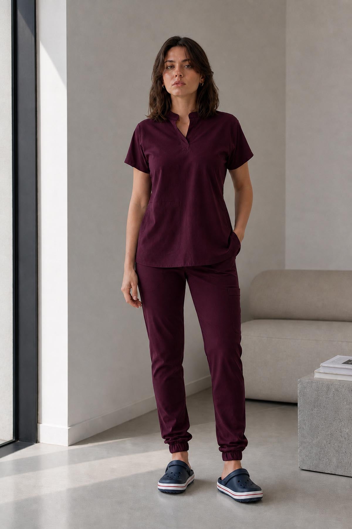 Asistenta medicala purtand bluza uniforma medicala grena unisex, model Scrub Activity, vedere din fata