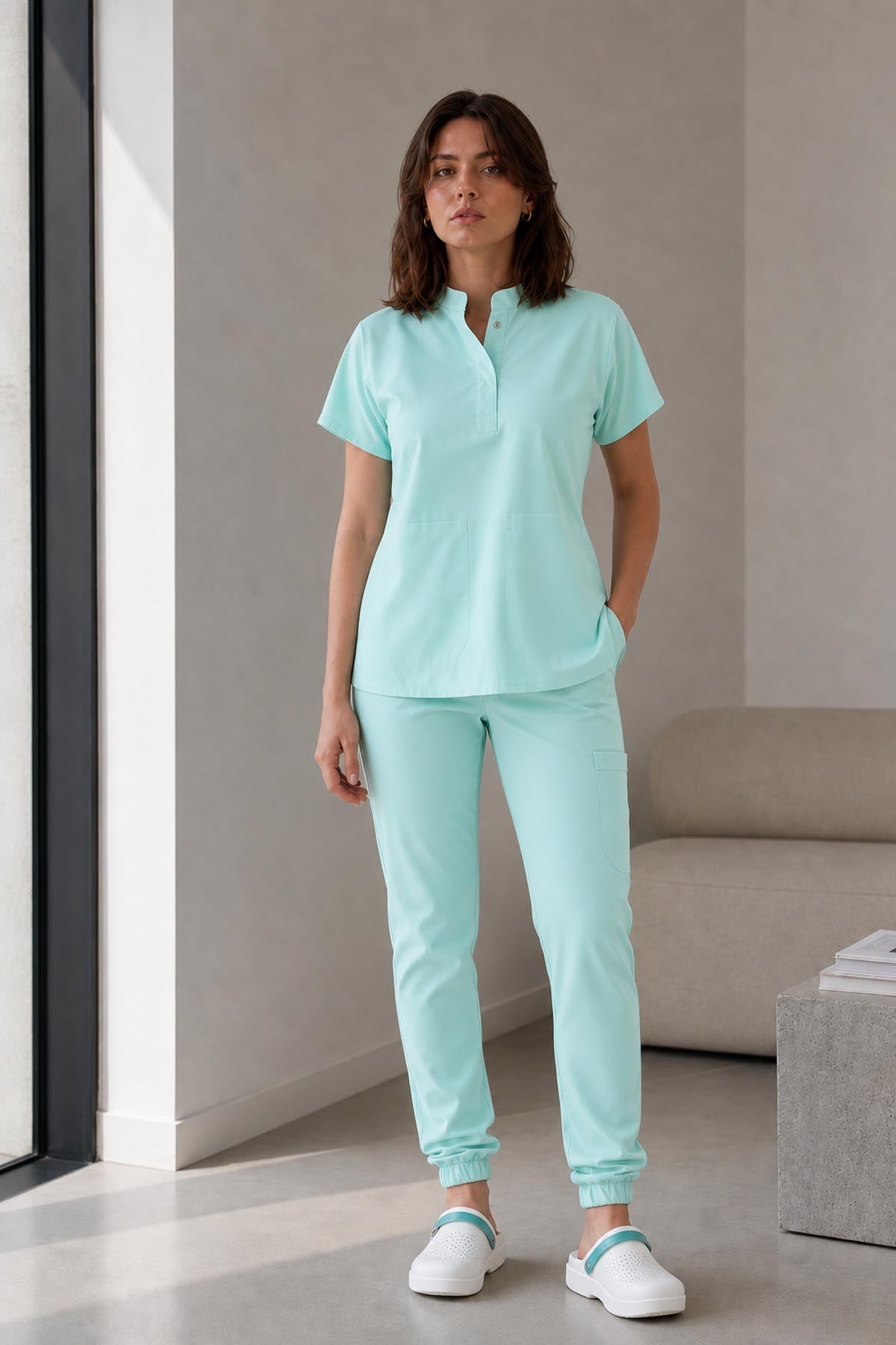 Asistenta medicala purtand bluza uniforma medicala verde menta unisex, model Scrub Activity, vedere din fata