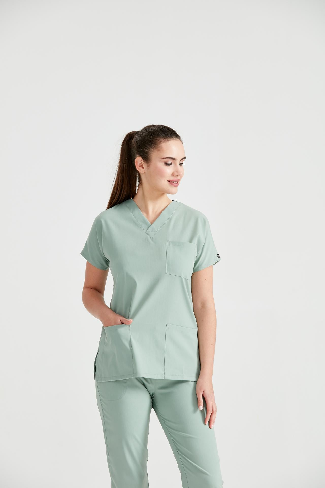 Asistenta medicala imbracata in costum medical de dama din elastan, verde fistic, vedere din fata