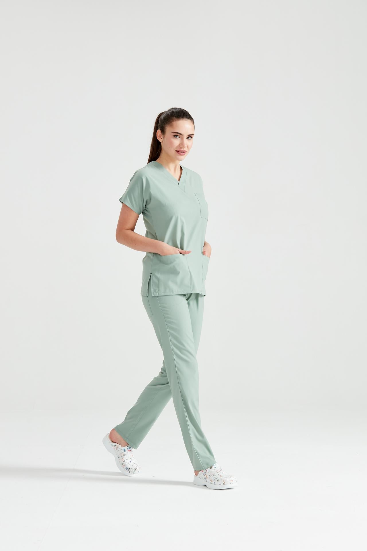 Asistenta medicala imbracata in costum medical de dama din elastan, verde fistic, vedere din profil