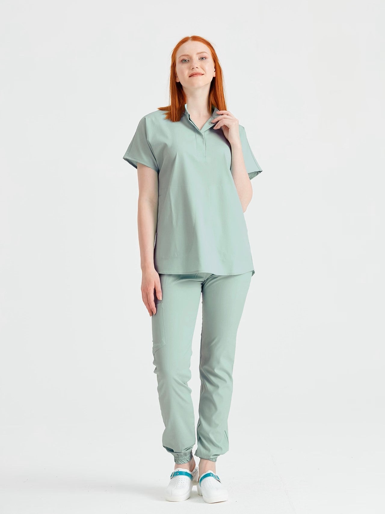 Asistenta medicala imbracata in costum medical de dama verde fistic, vedere din profil