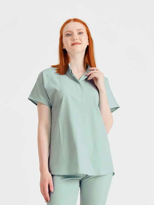 Asistenta medicala imbracata in costum medical de dama verde fistic, vedere din fata
