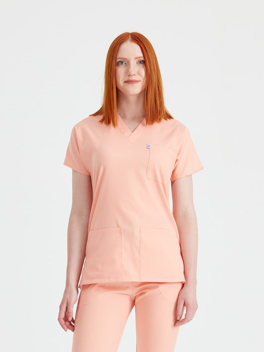Asistenta medicala imbracata in costum clasic flex Peach, roz piersica vedere din fata