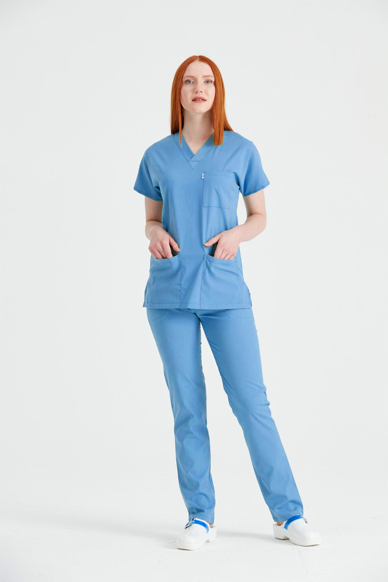 Asistenta medicala imbracata in costum medical de dama din elastan, albastru parlament, vedere din profil