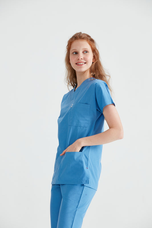  Asistenta medicala imbracata in costum albastru Parliament Blue, cu mainile in buzunar, vedere din fata
