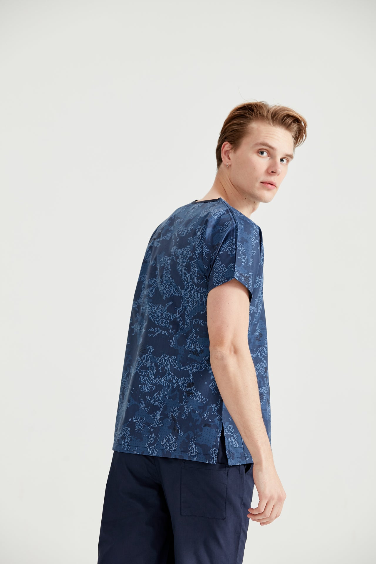 Asistent medical imbracat in bluza medicala Camouflage Bleumarin, vedere din spate