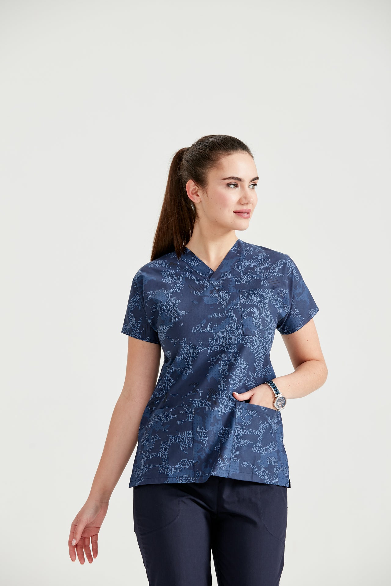 Asistenta medicala imbracata in bluza Camouflage Bluemarin, cu mana in buzunar, vedere din fata