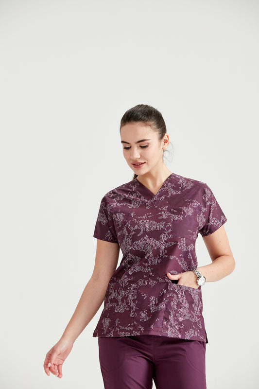 Asistenta medicala imbracata in bluza Camouflage Purple, cu mainile in buzunar, vedere din fata