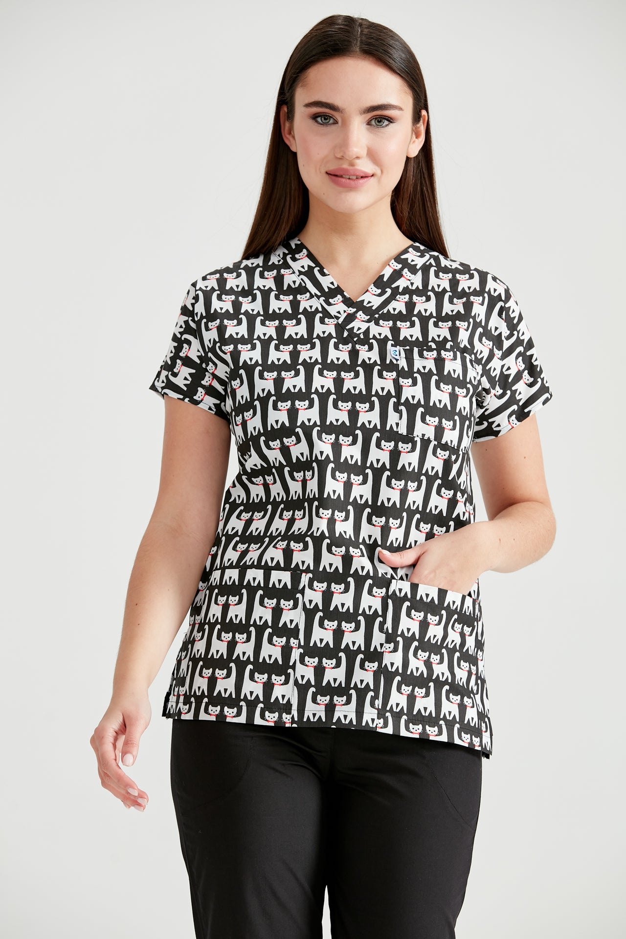 Asistenta medicala imbracata in bluza Cat Black, cu mainile in buzunar, vedere din fata