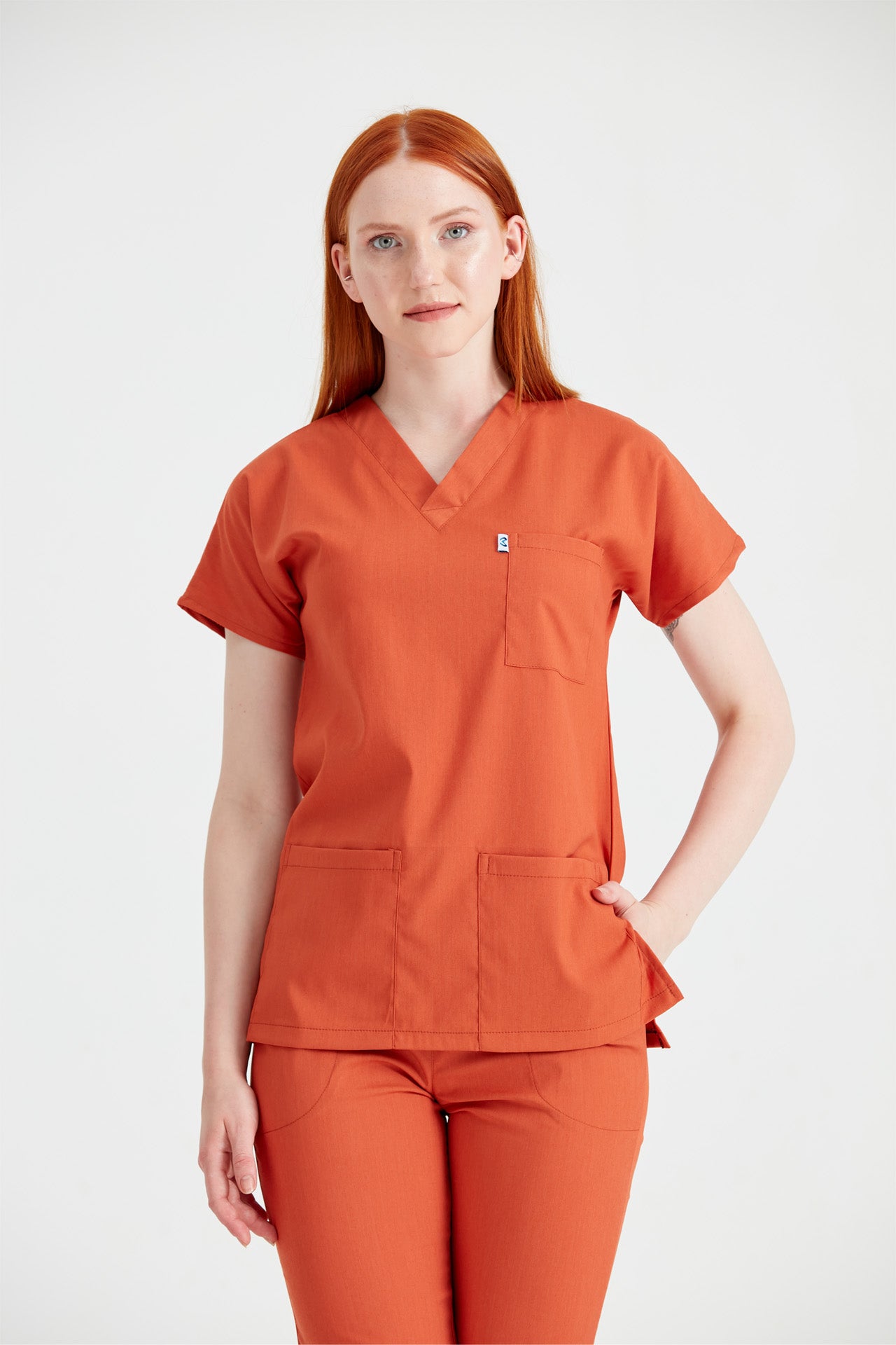 Asistenta medicala imbracata in costum din elastan Caramiziu, vedere din fata