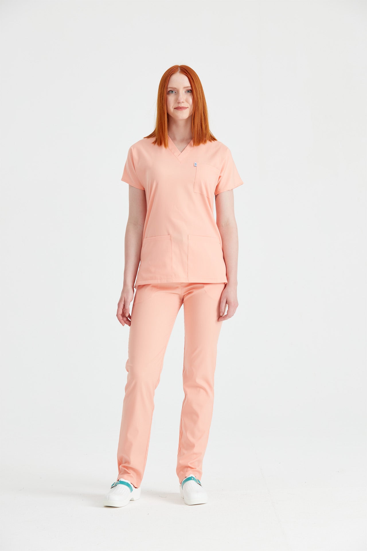 Asistenta medicala imbracata in costum din elastan Peach, roz piersica, vedere din picioare