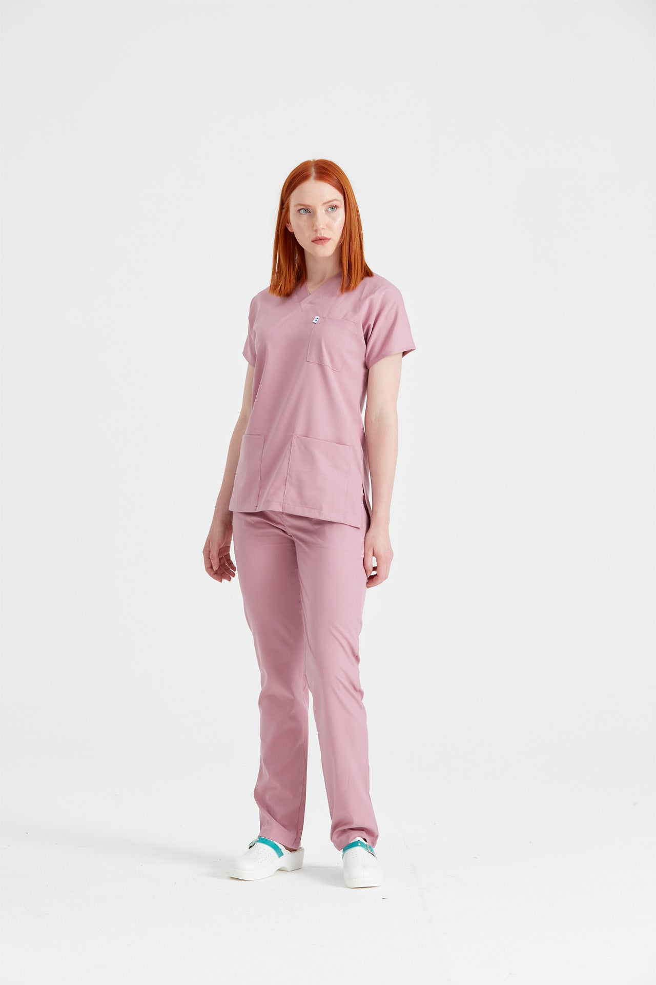 Asistenta medicala imbracata in costum medical roz clasic flex Rose, vedere din picioare