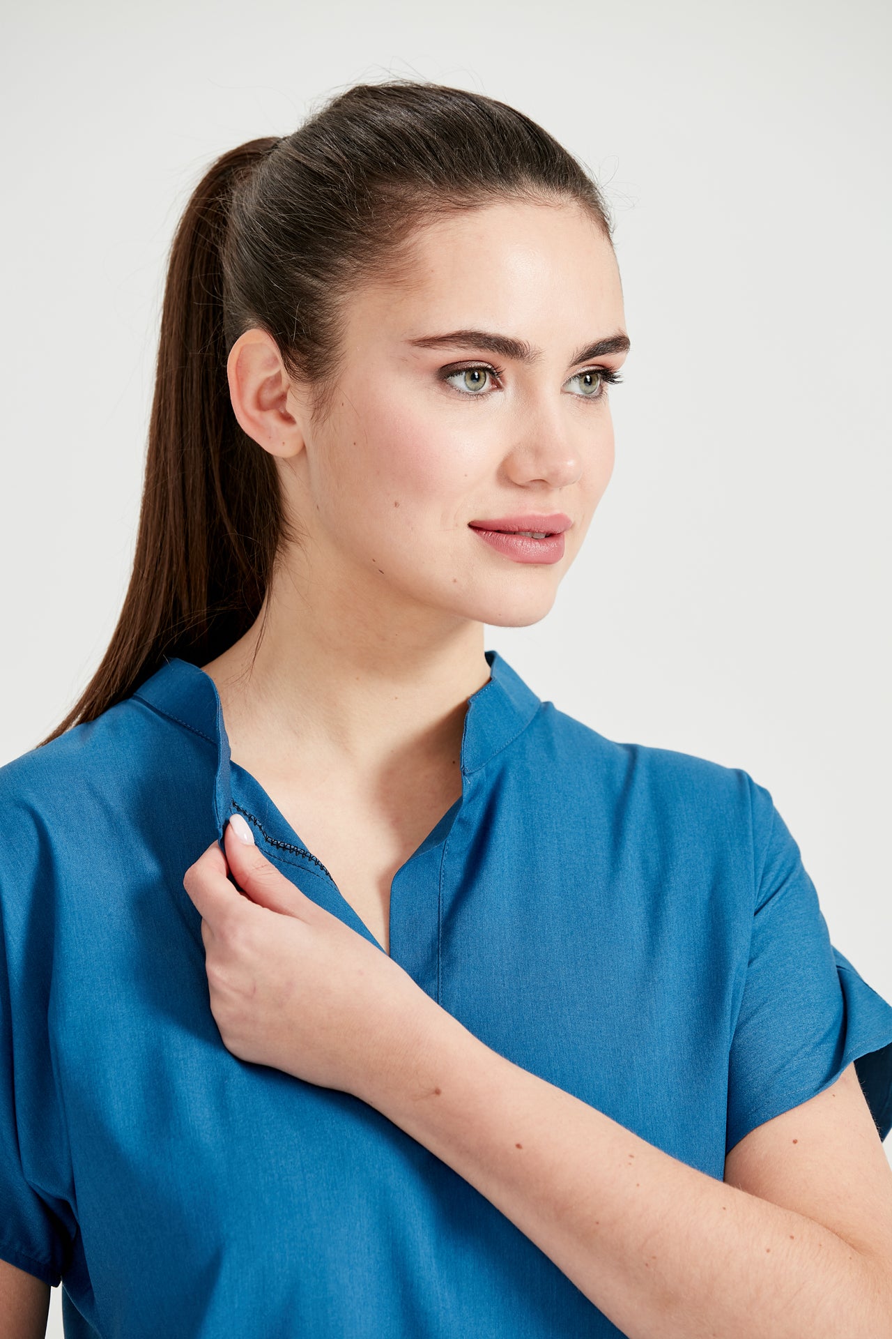 Asistenta medicala imbracata in costum medical albastru Petrol Blue, vedere din fata