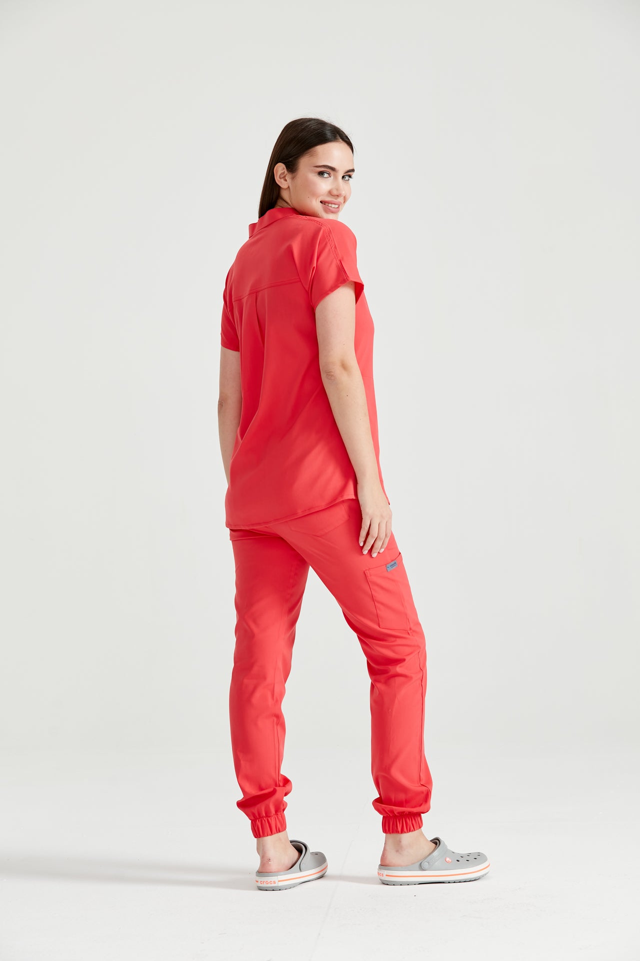 Asistenta medicala imbracata in costum medical de dama, rosu corai, Coral, vedere din spate