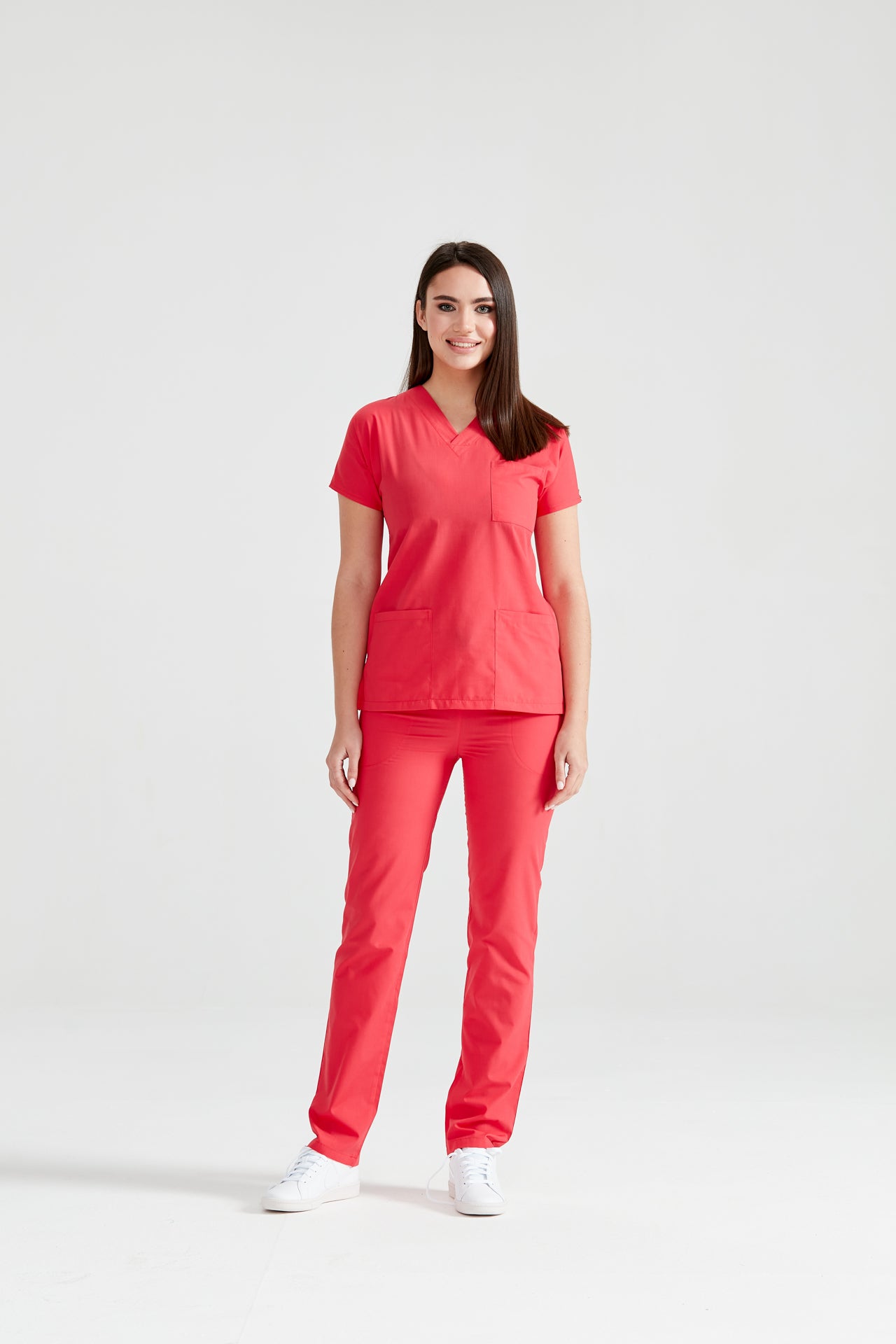 Asistenta medicala imbracata in costum Corai Red, vedere din fata