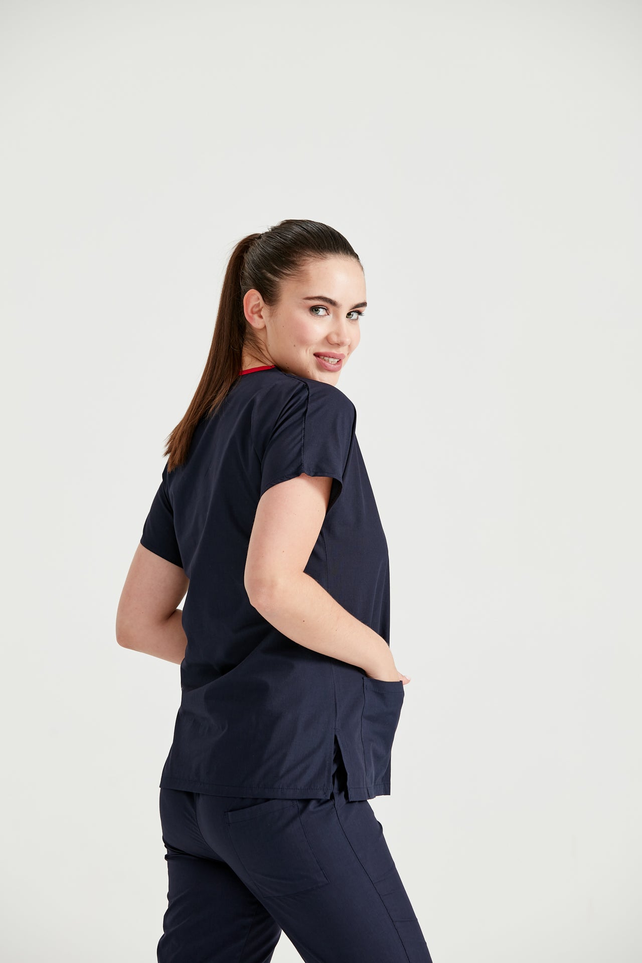 Asistenta medicala imbracata in costum medical de dama din elasta, Bleumarin, vedere din profil 