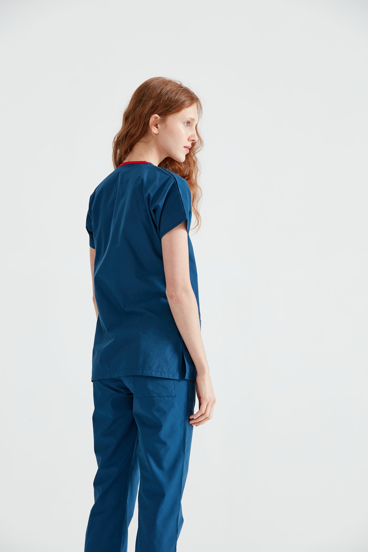 Asistenta medicala imbracata in costum Indigo, vedere din spate