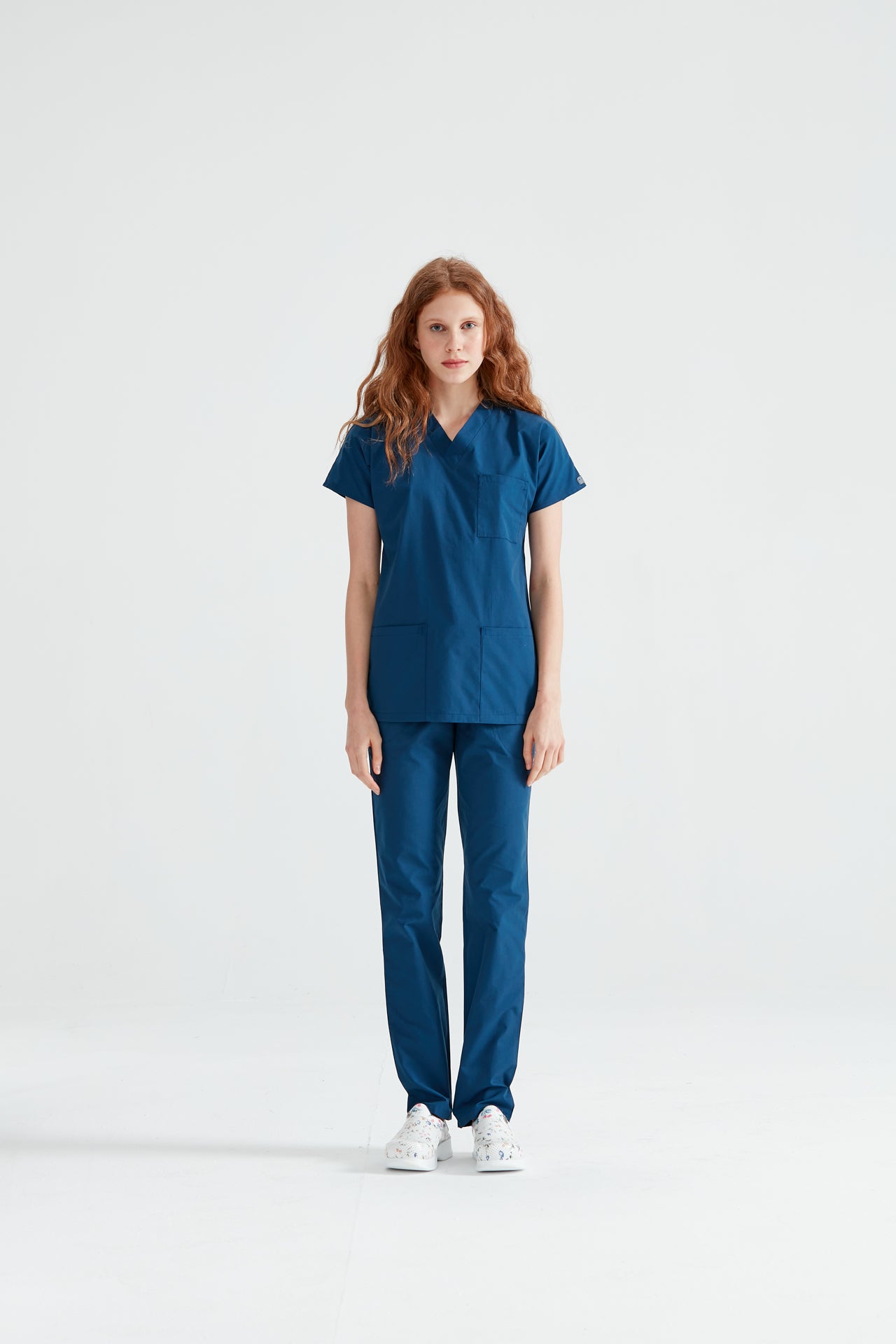 Asistenta medicala imbracata in costum Indigo, vedere din picioare