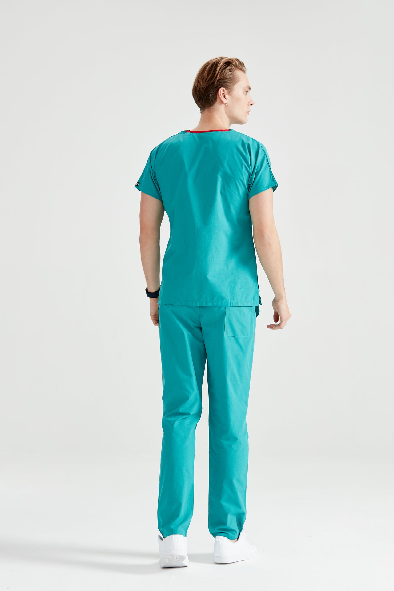 Asistent medical imbracat in costum medical verde chirurgical Surgical Green, pentru barbati, vedere din spate