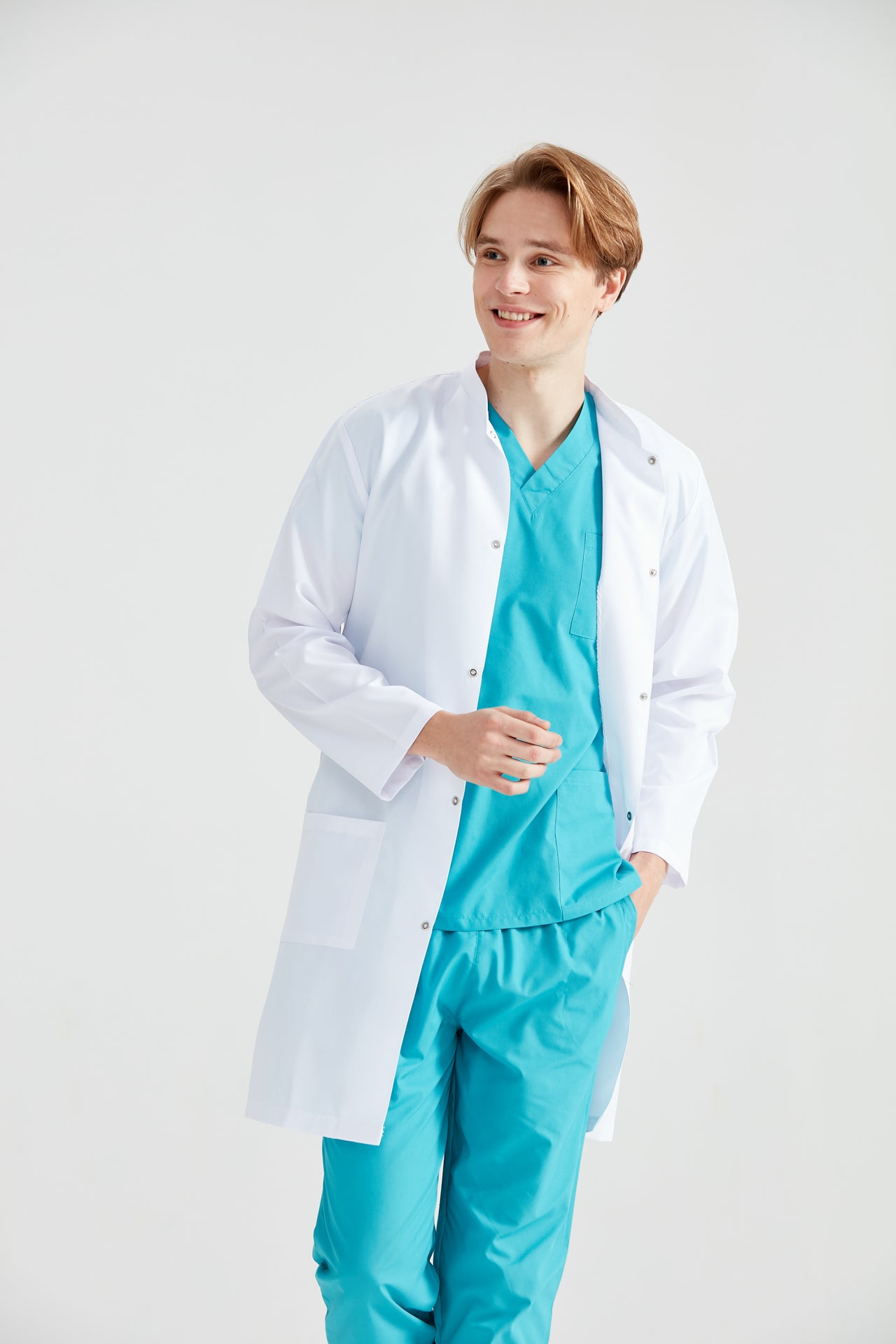 Asistent medical imbracat in halat Dr. Tunica Long, cu mainile in buzunar, vedere din fata