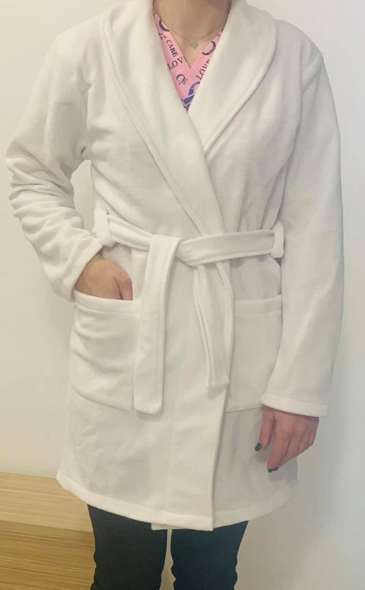 asistenta medicala imbracata intr-un halat medical polar alb, cu buzunare si cordon in talie