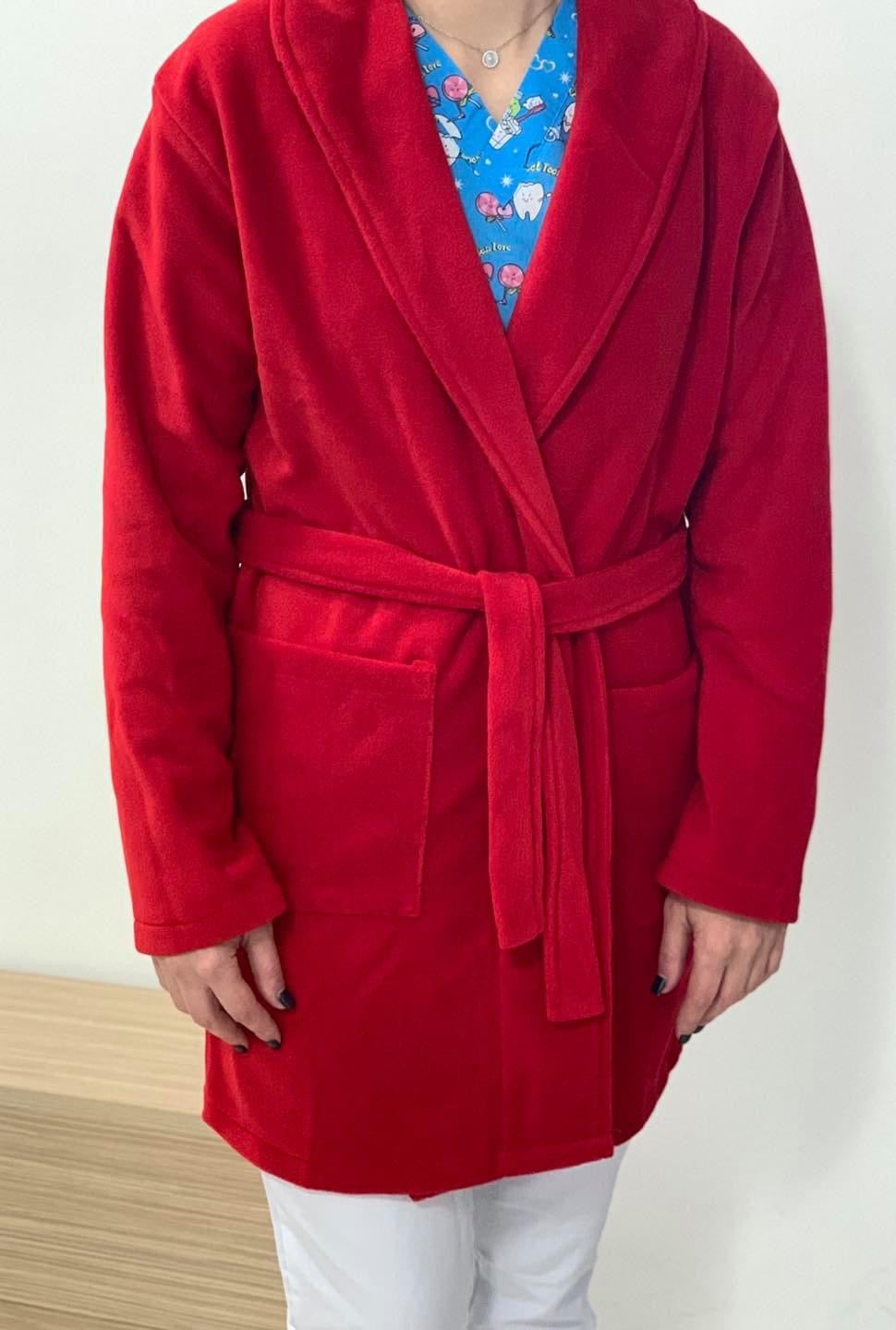 asistenta medicala imbracata intr-un halat medical polar rosu cu buzunare si cordon in talie