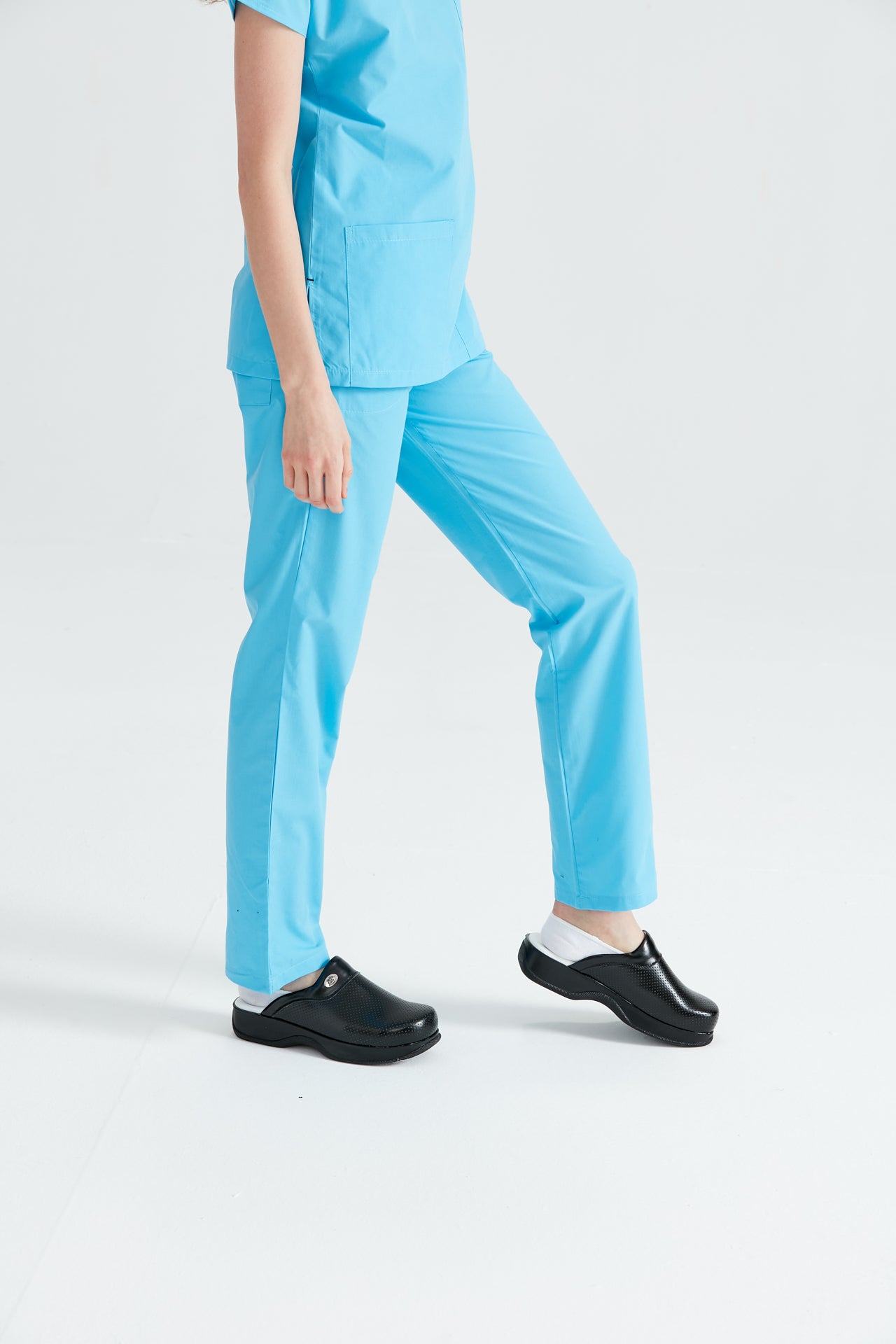 Asistenta medicala imbracata in pantaloni Turquoise, vedere din profil